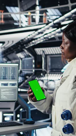 vertical video astronaut monitoring system diagnostics on monitor, talking to colleague