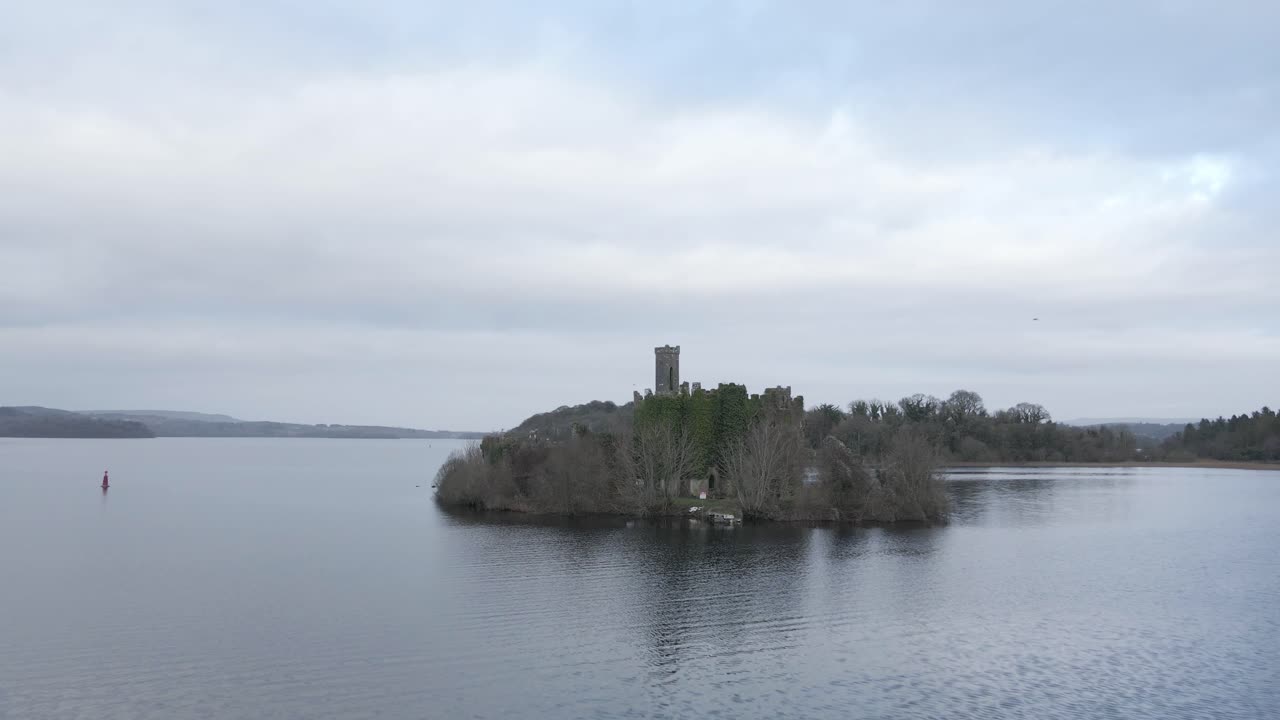 aproximación aérea de drones de las ruinas del castillo de mcdermott cubiertas de hiedra en una isla en lough key, condado de roscommon