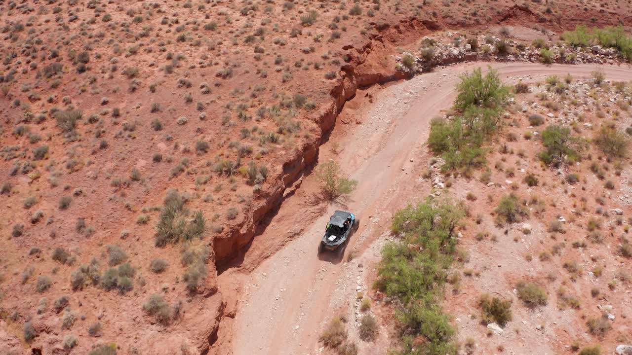 Aerial view of a Dune Buggy driving along a dry and dusty road
