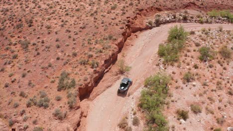 aerial view of a dune buggy driving along a dry and dusty road