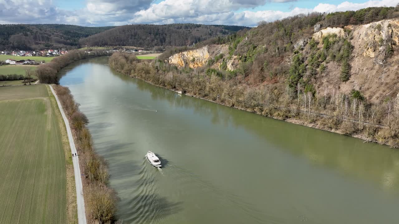 A beautiful aerial shot of a boat on the Danube River, showing the importance of the waterway in a setting of breathtaking natural beauty