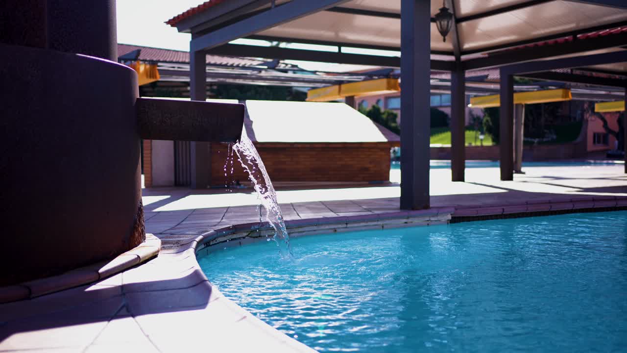 Luksuriøs springvand ved poolen i en solbeskinnet privat villa.