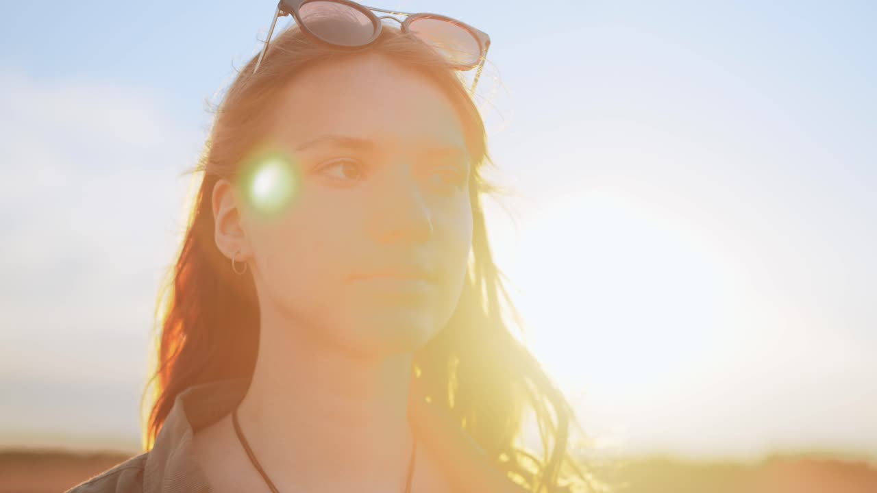 Beautiful young woman, portrait of girl's face at sunset, arc shot slow motion