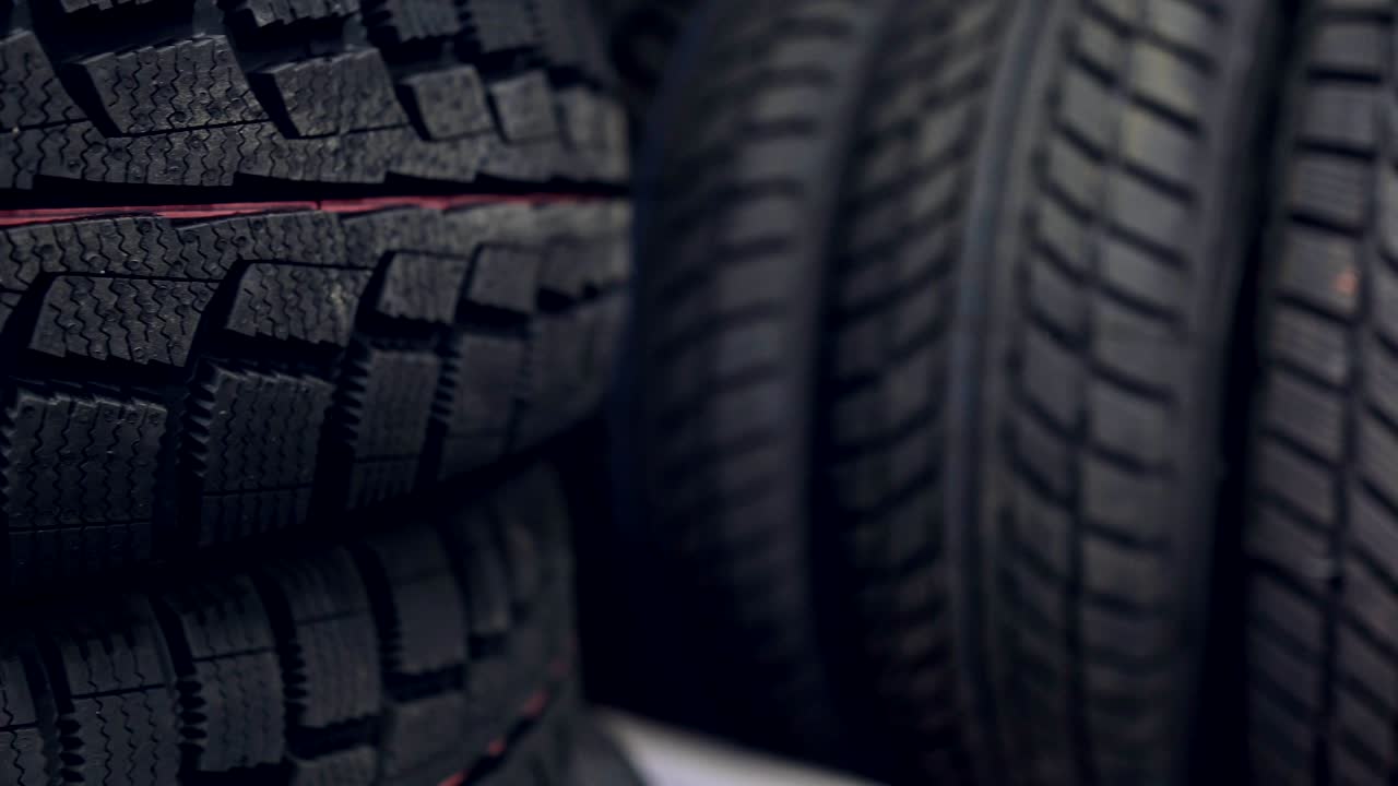 muchos neumáticos de invierno nuevos en los estantes y en las columnas. panorama de la tienda.