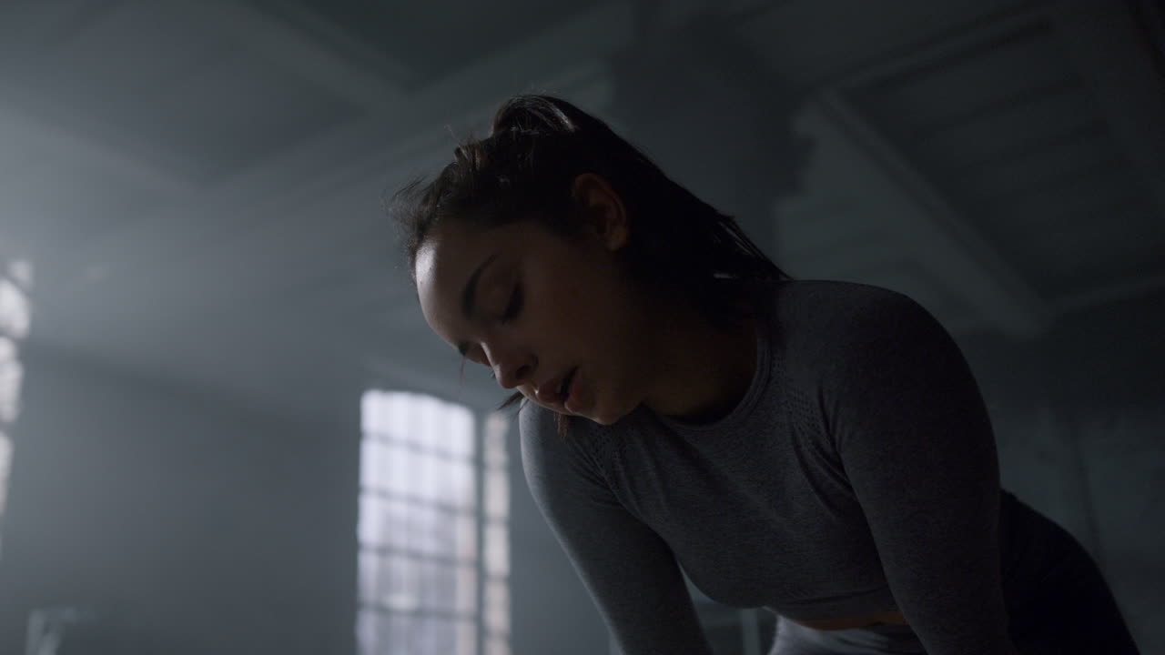 Sportswoman standing in gym after training. Athlete taking rest between exercise