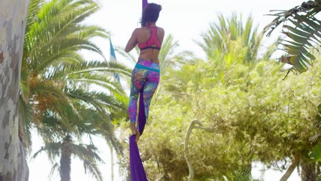 Female-acrobat-working-outdoors-on-silk-ribbons