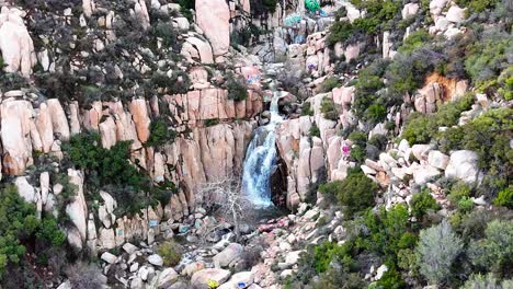 Luftaufnahme-Eines-Wasserfalls-Mit-Graffiti-Und-Markierten-Felsen-Drumherum