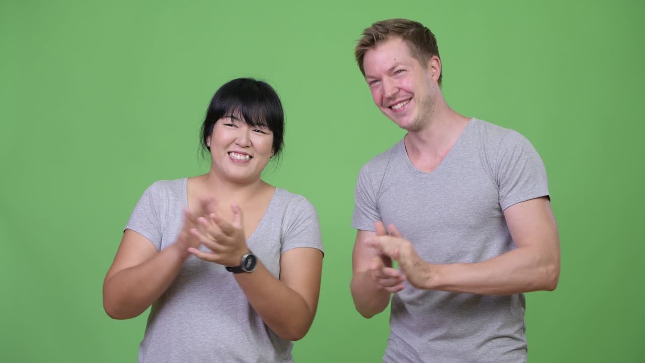 행복한 다민족 커플이 함께 손을 치고 있습니다.