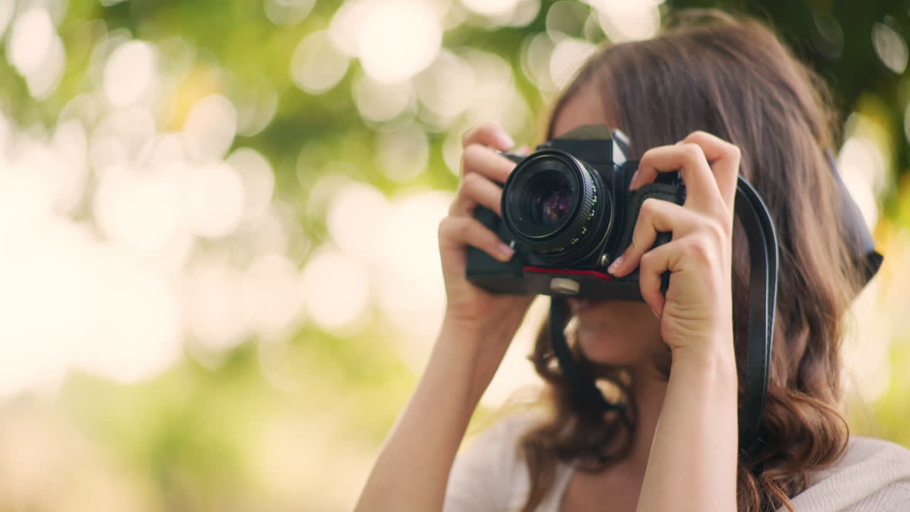 Young girl taking pictures with vintage film camera
