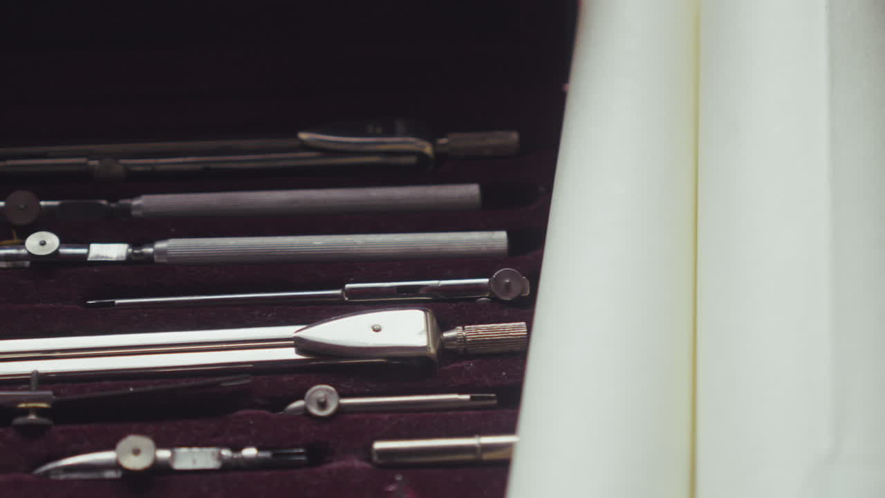 Close-up pan revealing a geometry set, highlighting precision tools used in drafting, engineering, and structured creative work