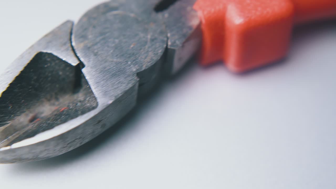 movimiento por encima de las alicates de corte con mangos en superficie blanca