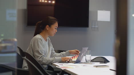 businesswoman working late in office meeting room using laptop