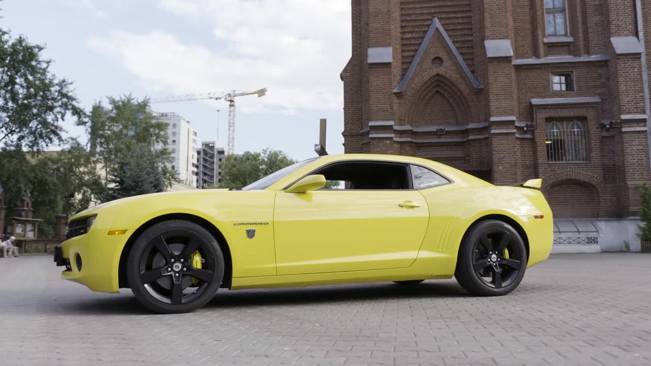 도시의 교회 앞에 주차된 노란색 카마로