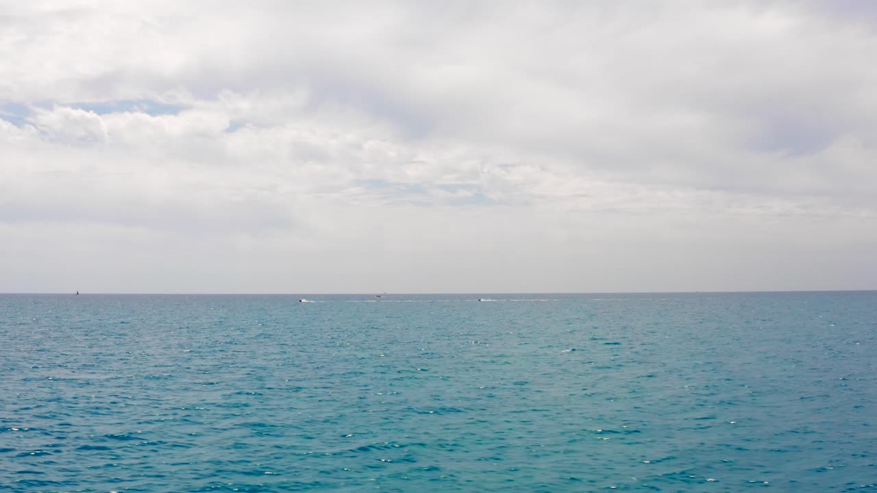 Distant View Of Jetski At The Blue Ocean Under Cloudy Sky. tracking shot