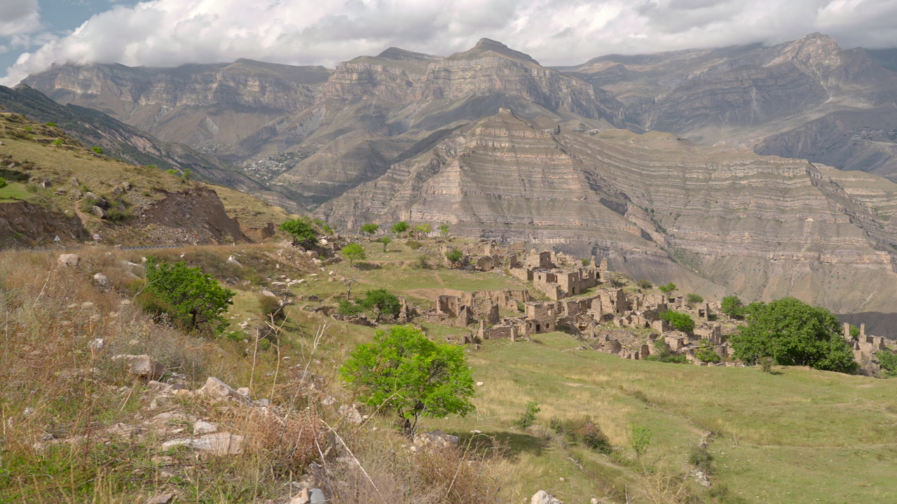 Ancient Stone Village Perched On Mountain Ridge, Terraced Fields And Dry Grass In Foreground, Clustered Stone