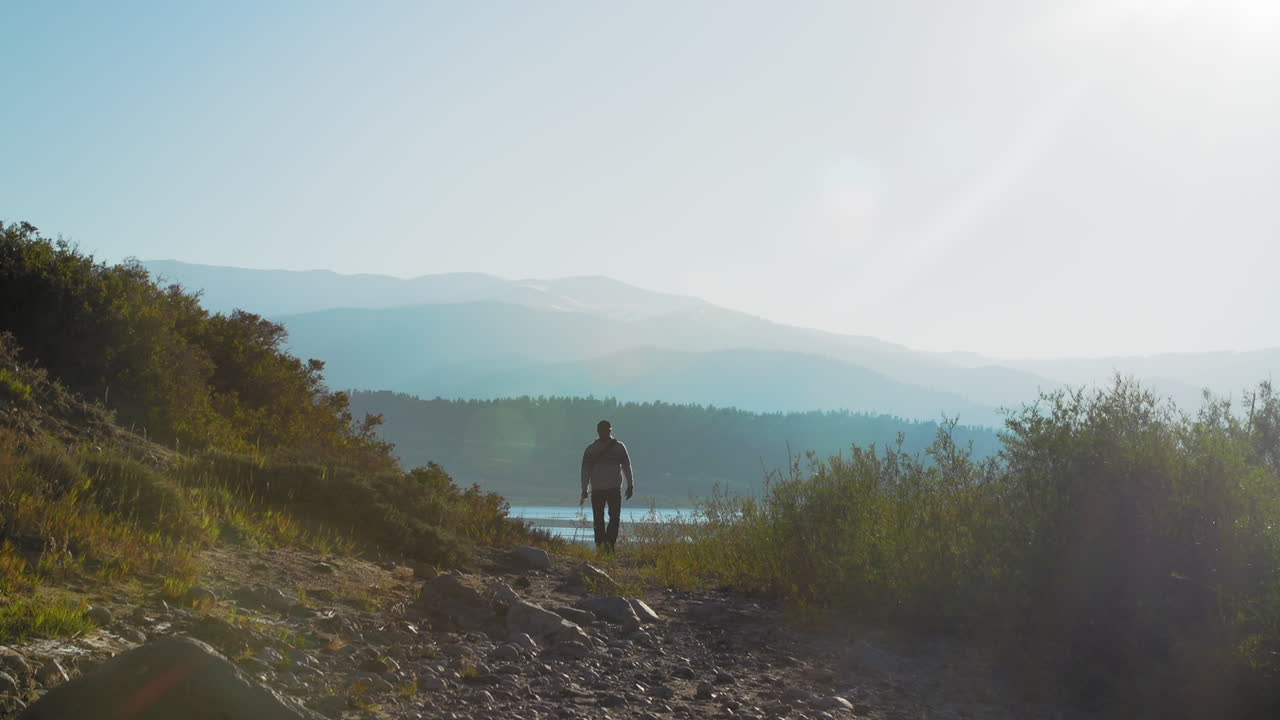 호수에서 멀리 하이킹하는 어부의 와이드 샷