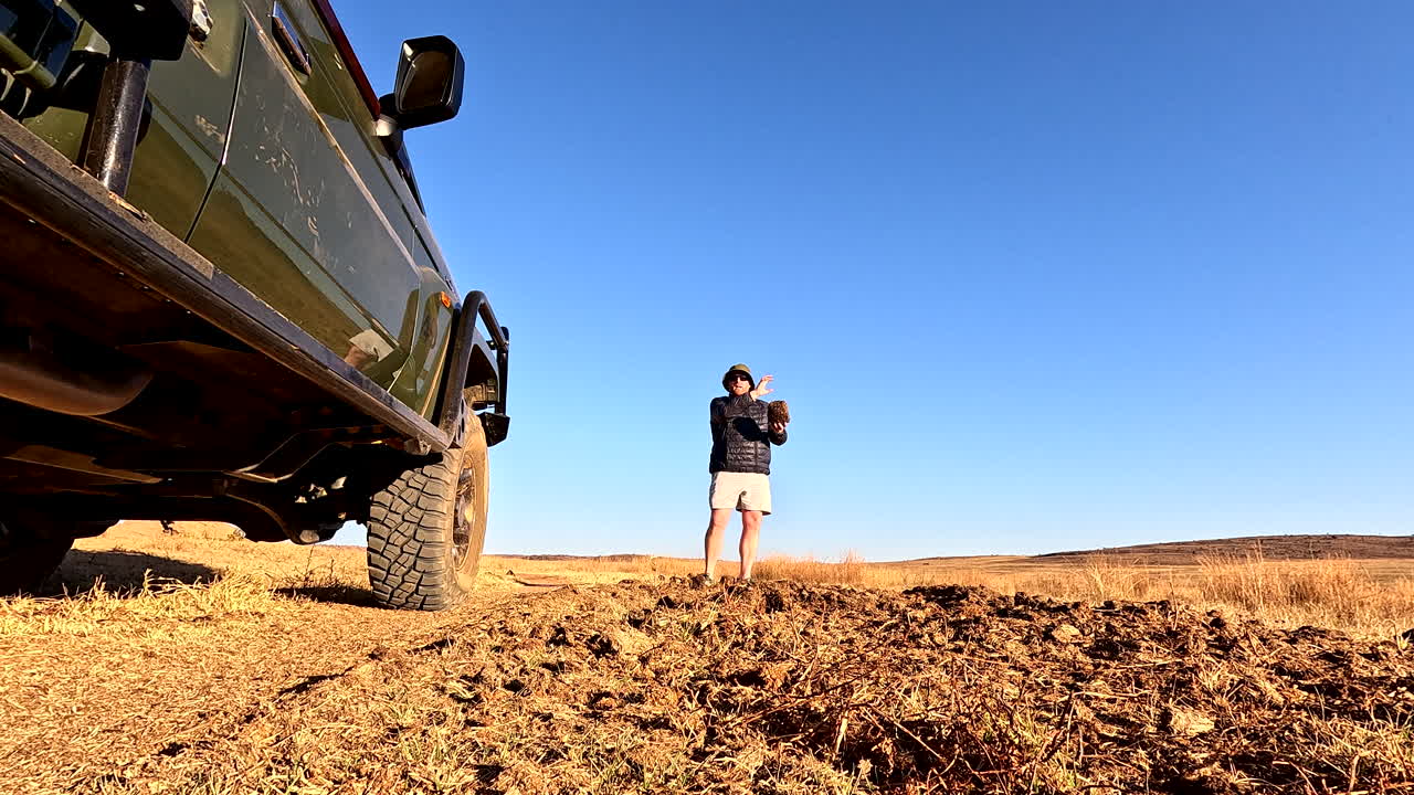 Game ranger explains to guests on safari truck what elephant dung looks like