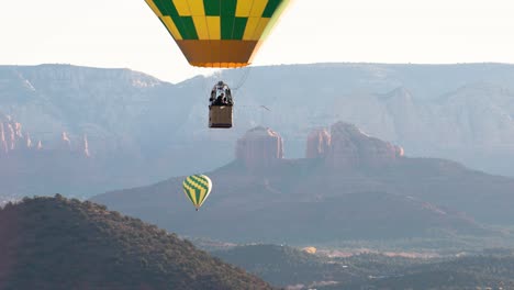 Globo-Aerostático-Desciende-Con-La-Roca-Catedral-En-El-Fondo,-Sedona,-Arizona