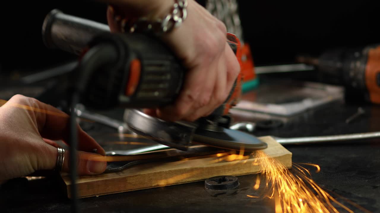 cerrajero de cerca trabaja con la máquina de moler, volar chispas brillantes