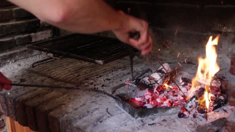 Statische-Aufnahme-Von-Händen,-Die-Holzkohle-Unter-Dem-Grill-Verteilen