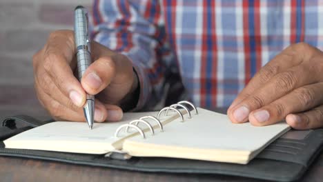 persona que escribe en un cuaderno