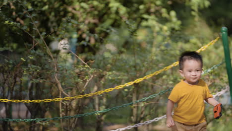 asian boy holding toy car