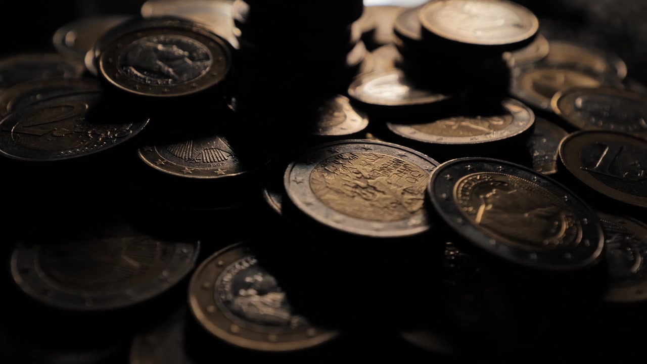 Towering euro coins in dramatic shadow, symbolizing wealth, resource gathering