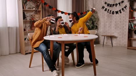 a family taking a halloween selfie with monster tooth masks
