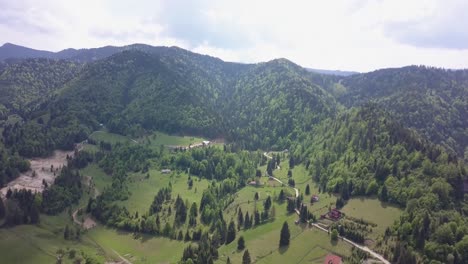 toma panorámica aérea de gran altitud hacia arriba de la cordillera en la distancia con bosques verdes con cielo azul