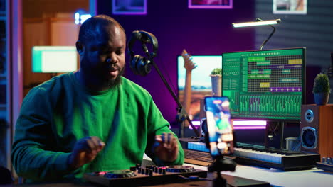 productor de música explicando faders y botones en la consola de mezcla antes de la enseñanza
