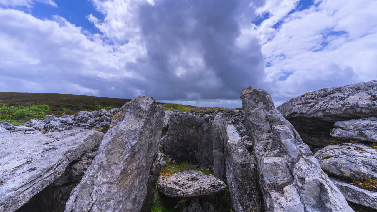 Tidsforløbsvideo af et landligt landskab med neolitisk klippeformation i forgrunden under en forbipasserende regnvejrsdag, set fra Carrowkeel i Sligo County på Irland