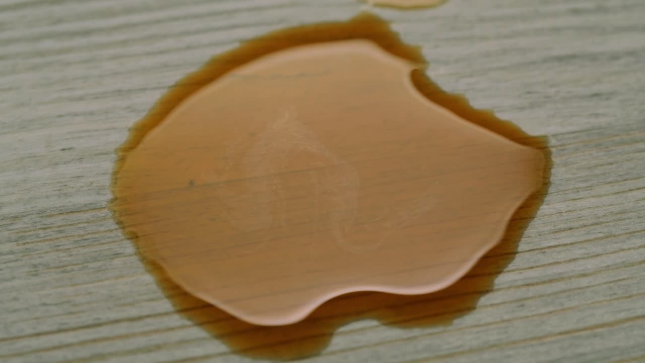Carta assorbente che assorbe un liquido versato su una superficie di legno