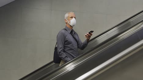 caucasian man out and about in a metro station wearing on a face mask against coronavirus