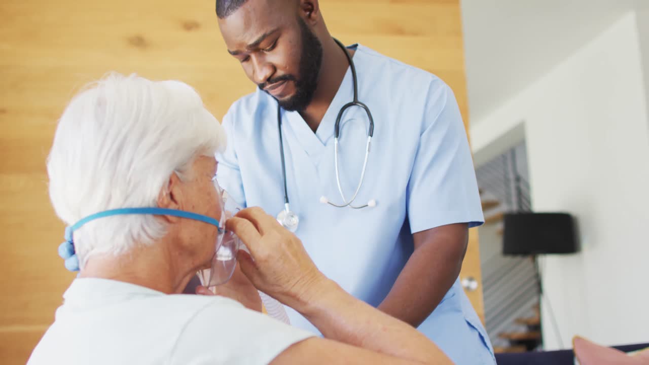 Video van Afro-Amerikaanse mannelijke dokter die zuurstof toedient aan een Kaukasische oudere vrouw.