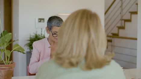 serious realtor sitting at table, wearing eyeglasses and getting ready for signing contract with clients