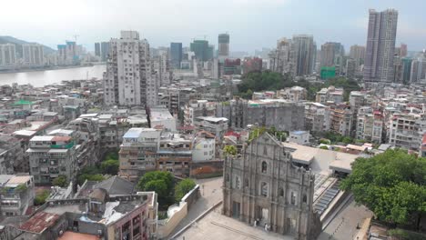 rotating and tilting aerial view of ruins of saint paul's revealing macau cityscape