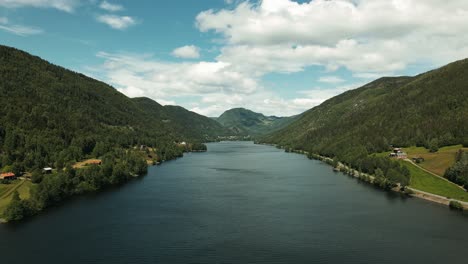 Drone flying in reverse over a lake in the mountains. Beautiful summer day