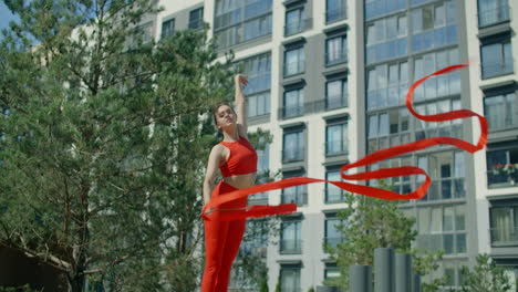 woman twirling red ribbons in an urban setting