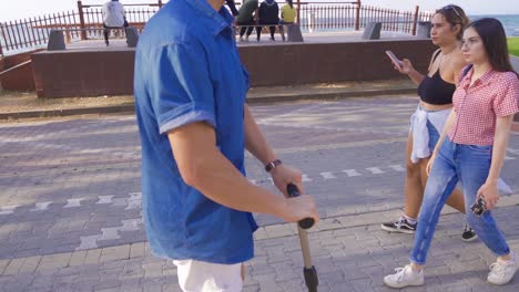 Young-man-rides-scooter-on-the-beach.