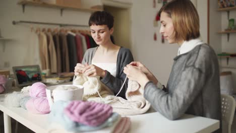 Two-woman-knitter-working-together-in-textile-workshop.-Knitting-hands