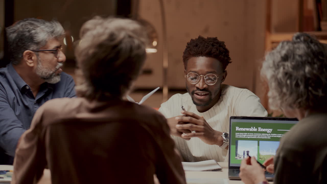 Group of Engineers Discussing Renewable Energy Strategies in Office