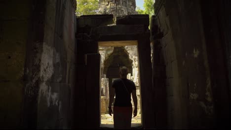 rear view of caucasian female adult exploring inside of the angkor wat complex, siem reap, cambodia