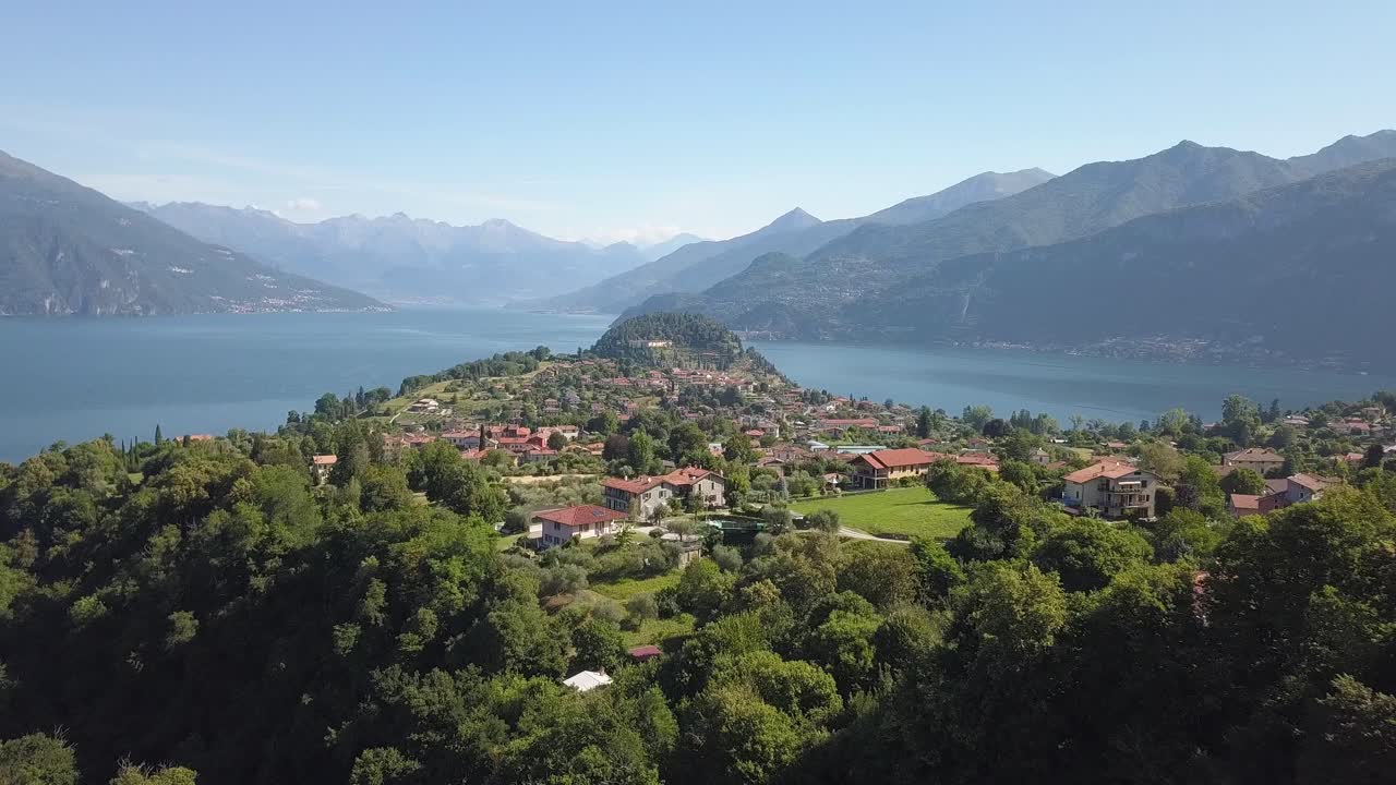 volar sobre un pequeño pueblo cerca de un lago en la zona montañosa de los alpes italianos, bellagio, lago di como, italia