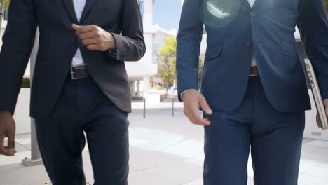 cropped shot of young businessmen walking outdoor