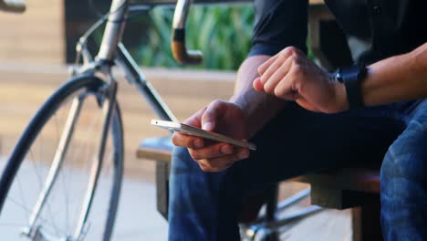 Man-checking-time-on-smartwatch-while-using-mobile-phone-4k