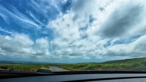 countryside view from car dashcam pov driving along rural road in wales with open landscape with open land on either side. travel, transportation, nature footage