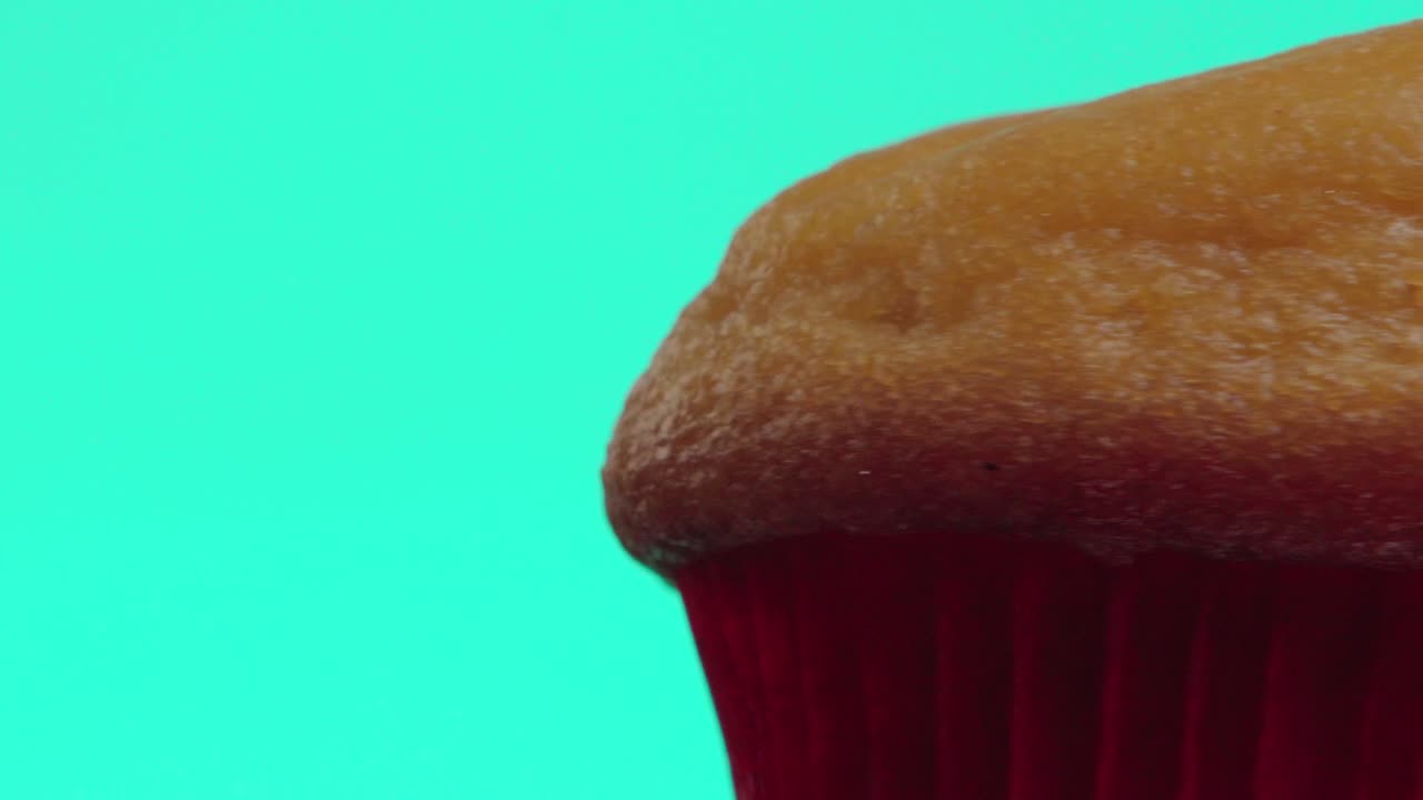 Primo piano di un muffin o cupcake tamales in rotazione su sfondo verde.