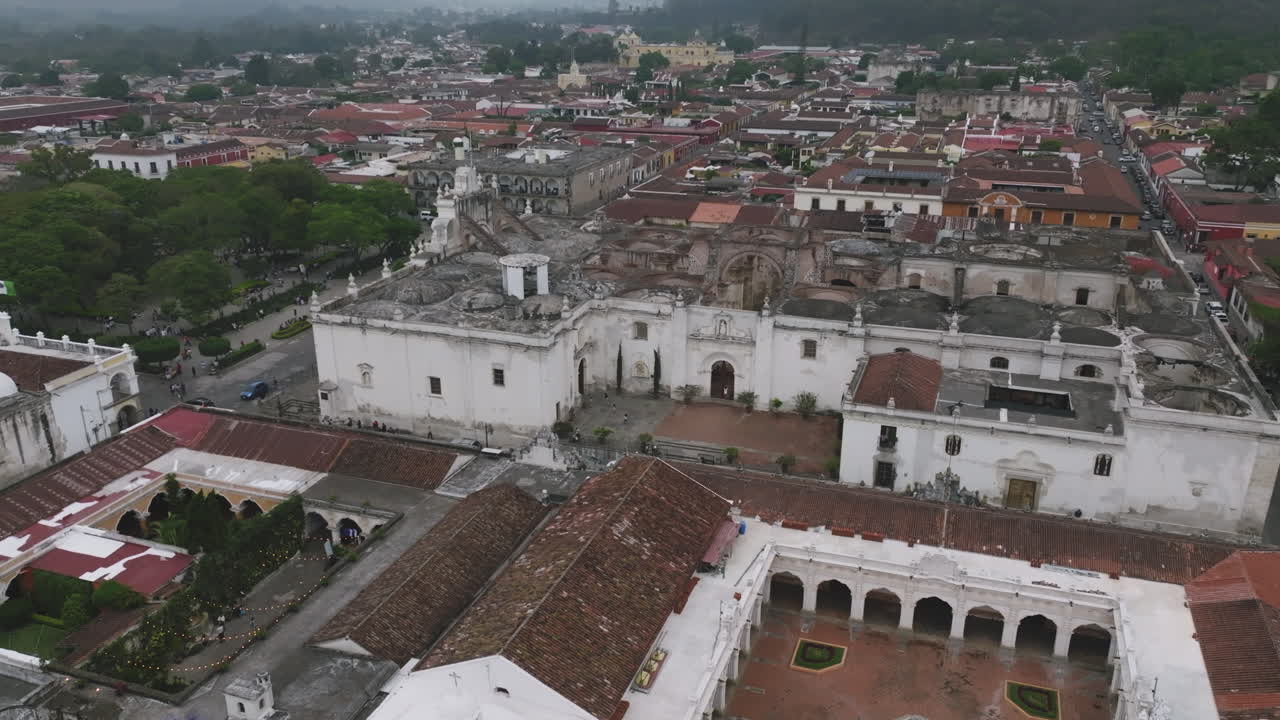 Riprese aeree che si muovono lentamente verso l'ingresso di una cattedrale storica ad Antigua, Guatemala.