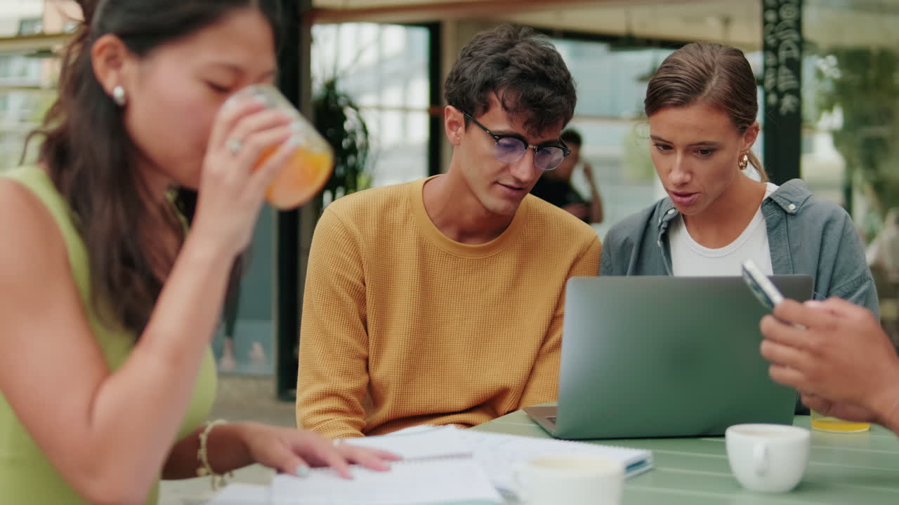 Students of different nationalities use modern technology outdoors, laptop for
