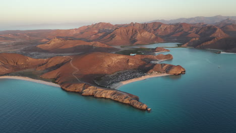 Filmische-Drohnenaufnahme-Von-Balandra-Beach,-Blick-Auf-Rote-Hügel,-Türkisfarbenes-Wasser,-Weiße-Sandstrände-Und-Berge,-Die-Sich-Langsam-Drehen